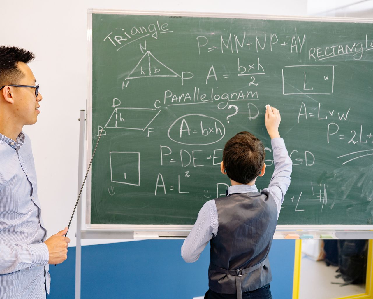 Crafting Captivating Headlines: Your awesome post title goes here Teacher and student engage in a geometry lesson, solving problems on the chalkboard.